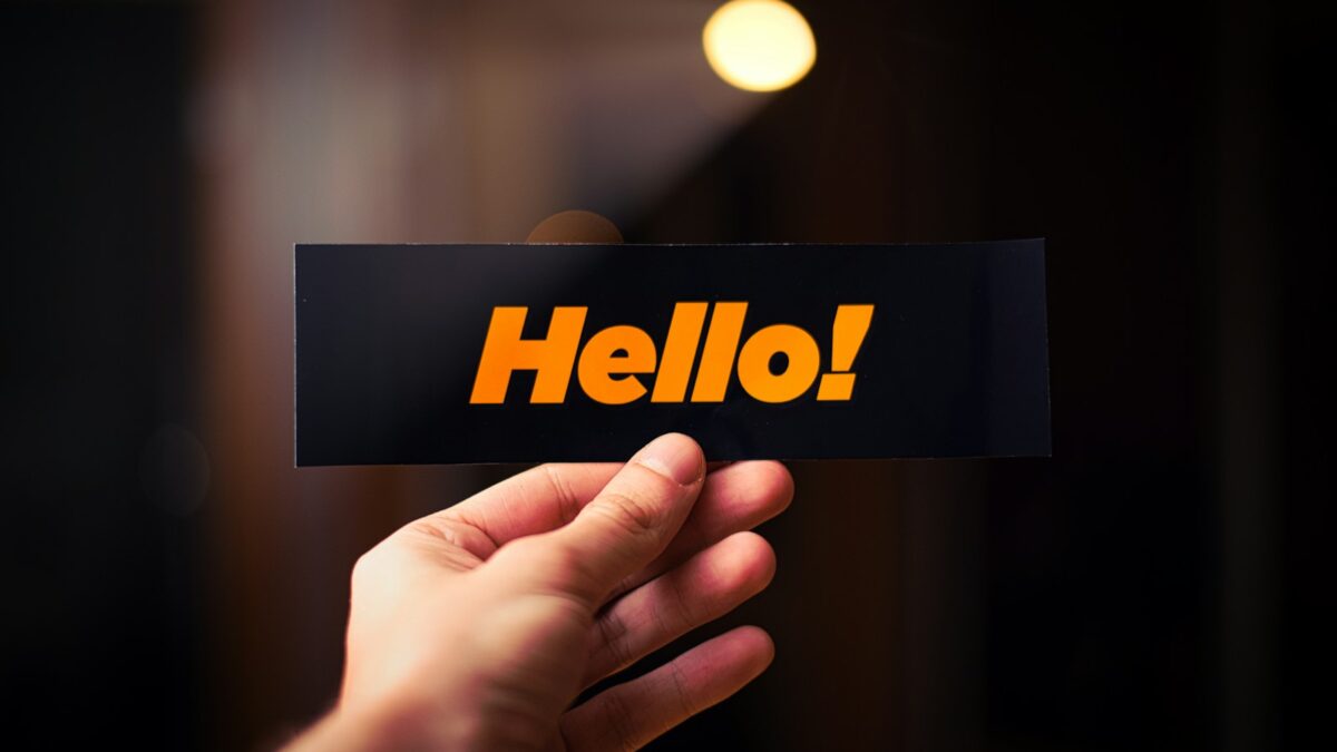 a person holding up a sign that says hello