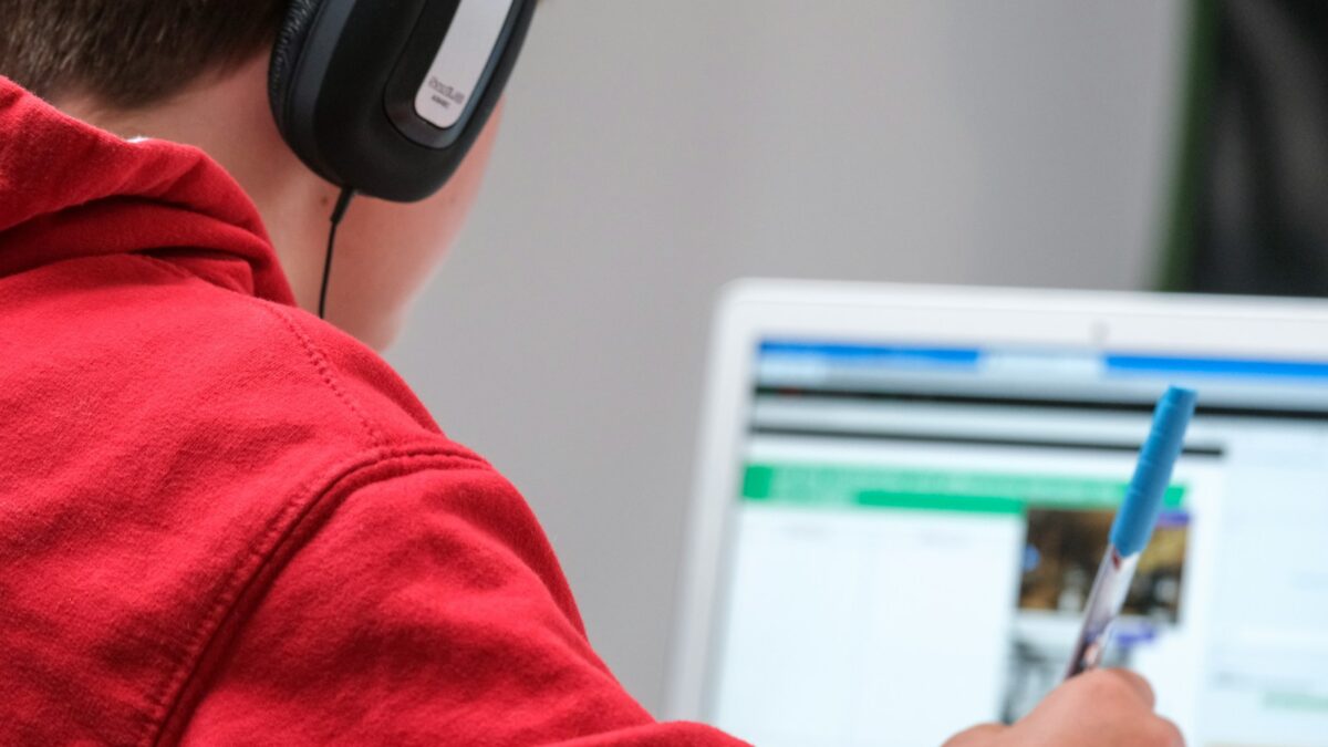 person in red shirt wearing black and gray headphones